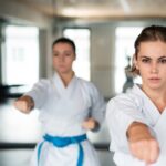 Group of young women practising karate indoors in gym